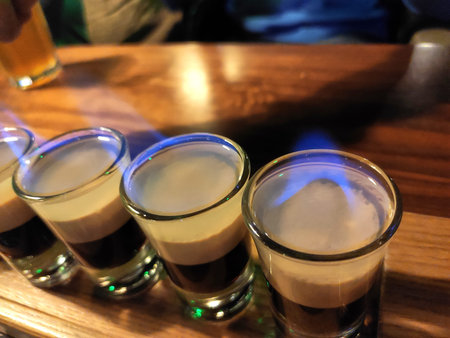 A number of burning B-52 cocktails on a wooden tableの写真素材