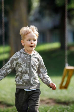 Adorable little boy running outside in slow-motion towards camera happy child runs.の写真素材