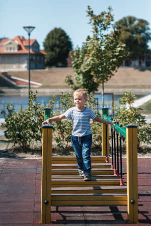A full-length portrait of a little boy in a striped sailor shirt in the port city of Klaipeda.の写真素材