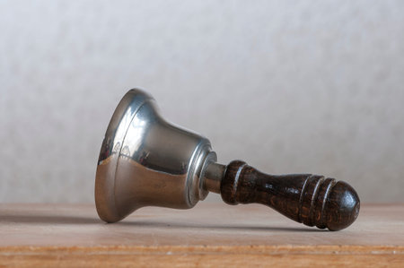 Hand bell lying on wooden boardの写真素材