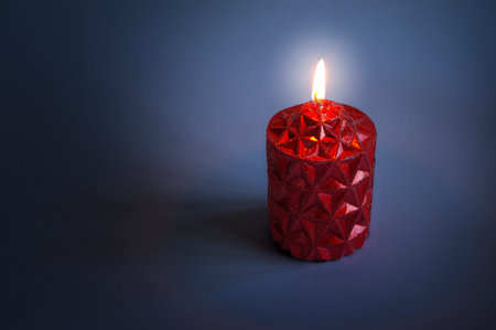 Red candle shining in the dark.の写真素材