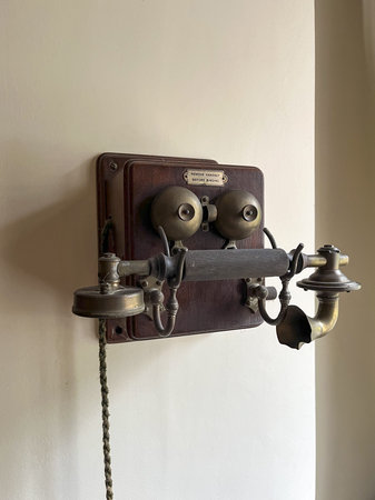 Antique telephone with bells attached to a wall.