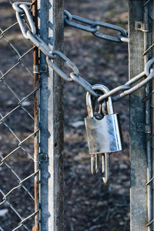 Photo of a metal padlock on a gate and fenceの写真素材