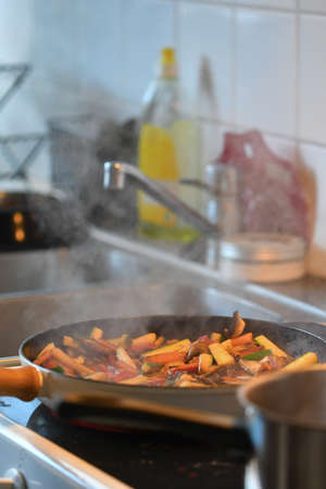 Photo of food being cooked in kitchen, frying vegetables in panの写真素材