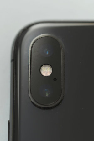Closeup macro of camera of a mobile smart phone on white background