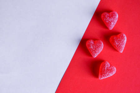 Photo of red jelly candy hearts on red and white backgroundの写真素材