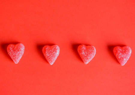 Photo of red jelly candy hearts on red background