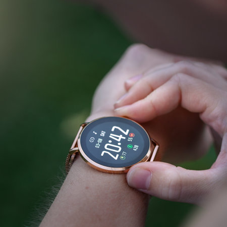 Closeup or macro of a woman looking at her watch outdoorsの写真素材