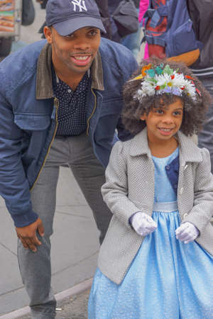 New York, New York: An African-American man and little girl in a blue dress and flowered bonnet pose for pictures at the Fifth Avenue Easter Parade.のeditorial素材