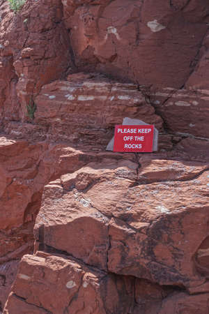 Sedona, Arizona: A sign in the Coconino National Forest asks visitors to keep off of the red sedimentary rocks.の写真素材