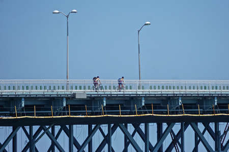 Brooklyn, New York: Two cyclists crossing the Marine Parkway Gil Hodges Memorial Bridge over Dead Horse Bay.の写真素材
