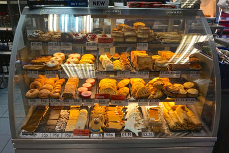 A display case full of sweet pastries in the town of Beauly, Inverness County, in the Scottish Highlands.のeditorial素材