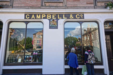 Beauly, Inverness County, Scotland: Two women shoppers looking at the window display at the historic Campbell and Co. of Beauly 1858 on the High Street.のeditorial素材