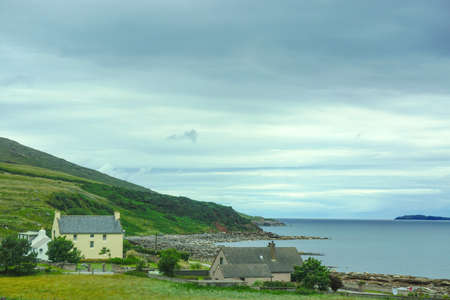 Achnasheen, Scotland: Houses along the shore of Gruirnard Bay, on the west coast of the Scottish Highlands, under a cloudy sky.のeditorial素材