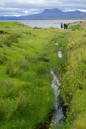 Mellon Udrigle, Scotland, UK: Three women walk along a creek with wildflowers at Mellon Udrigle Beach, on the west coast of the Scottish Highlands.のeditorial素材