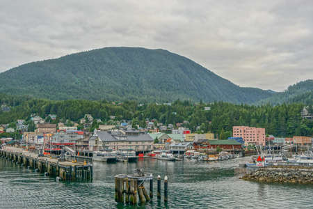 Ketchikan, Alaska: Shops at the harbor await the arrival of tourists, with a forest-covered mountain in the background.のeditorial素材
