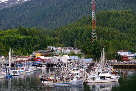 Ketchikan, Alaska: Fishing boats in the harbor, with a forest-covered mountain in the background.のeditorial素材
