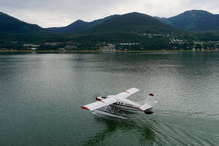 Juneau, Alaska, USA: A float plane prepares to take off from the waters of the Gastineau Channel at the harbor in Juneau, Alaska, on a summer evening.のeditorial素材