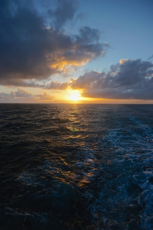 Thick white clouds over the horizon as the sun sets on the North Pacific Ocean between Sitka,...
