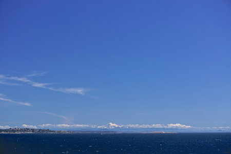 Morning at sea: Clouds and fog over Alaskan islands in the North Pacific Ocean with snow-capped...
