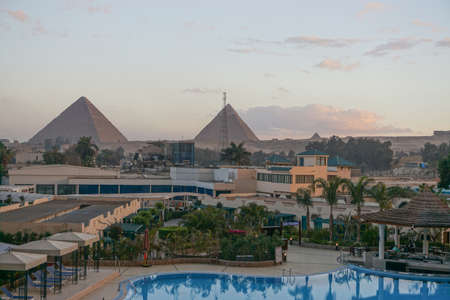 Giza, Egypt: View of the Khufu pyramid complex from the courtyard of a modern hotel.のeditorial素材