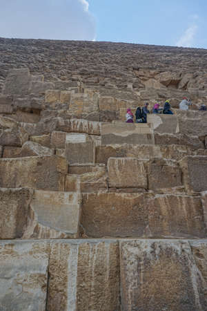 Giza, Egypt: Tourists line up at the entrance to the Great Pyramid at the Khufu pyramid complex, awaiting their turn to enter.のeditorial素材