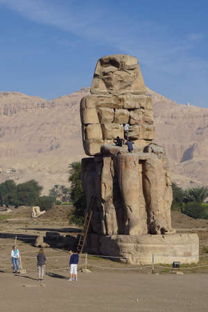 Luxor, Egypt: Men work to restore one of the Colossi of Memnon (1350 BC), a massive statue of Amenhotep III, who reigned during the 13th Dynasty.のeditorial素材