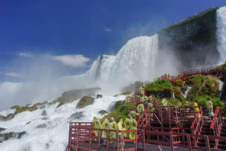 Niagara Falls, NY: Tourists in yellow raincoats enjoy the Cave of the Winds, stairs and platforms at the foot of the American Falls, on Goat Island.のeditorial素材