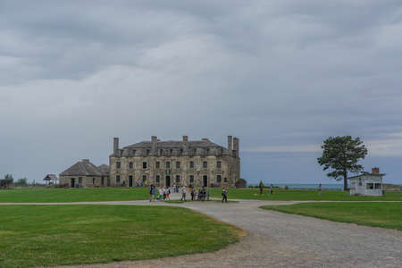Porter, New York, USA: Visitors on the 23-acre grounds of Old Fort Niagara; the 18th-century "French Castle" in the background, on a cloudy day.のeditorial素材