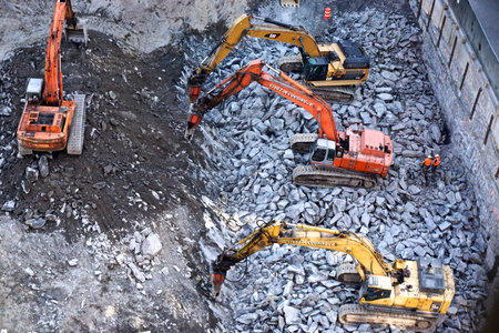 Workers watch as heavy machinery breaks up the Manhattan schist bedrock as construction begins on a high-rise building in midtown Manhattan, New York City.のeditorial素材