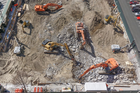 New York, New York: Heavy machinery breaking up Manhattan schist bedrock as construction begins on a...