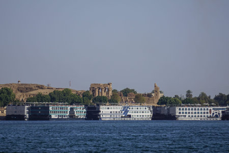 Kom Ombo, Egypt: Cruise ships lined up along the bank of the Nile River; the Kom Ombo Temple in the...