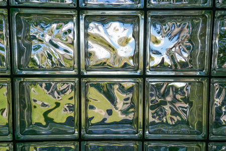 Abstract patterns in a wall of glass blocks.