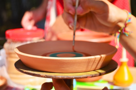 Potter shaping a ceramic plate on a pottery wheelの写真素材