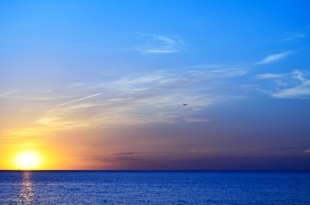 Colorful sunset over the blue sea with cloudsの写真素材