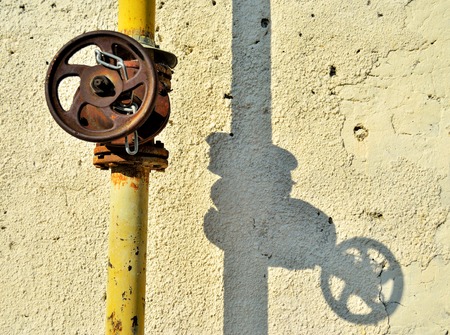 Gas control valve. The gas valve on the wall. Water tap on the street. Yellow pipesの写真素材