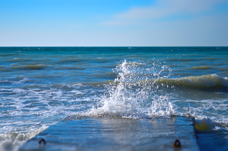 Powerful waves of the sea foam, breaking the concrete pierの写真素材