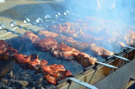Meat is fried on skewers over charcoal on the grillの写真素材