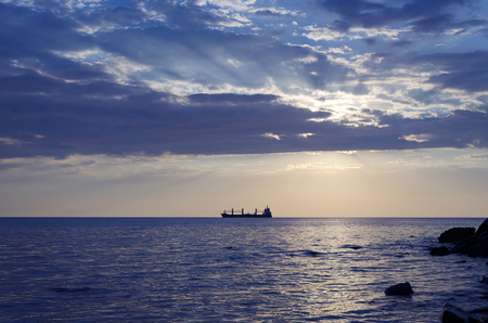 The ship that is laying a gas pipe on the sea bottom against the sunsetの写真素材