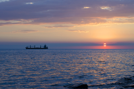 The ship that is laying a gas pipe on the sea bottom against the sunsetの写真素材