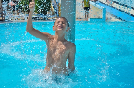 Teenager dives and has fun in aquapark. Splash in water.の写真素材
