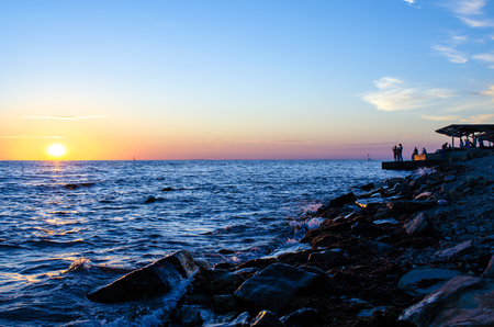 Silhouette of the fisherman over the sunrise and stones.の写真素材