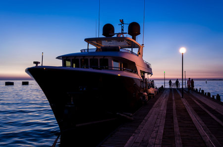 Luxury yachts in Anapa harbor at night with reflection in water. Russia.の写真素材
