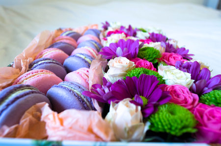 French macaroon cake. Violet and pink macaroons in a box with flowers on the bed.の写真素材