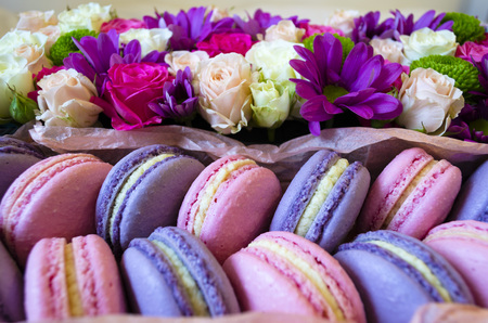 French macaroon cake. Violet and pink macaroons in a box with flowers on the bed.の写真素材