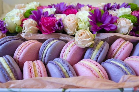 French macaroon cake. Violet and pink macaroons in a box with flowers on the bed.の写真素材