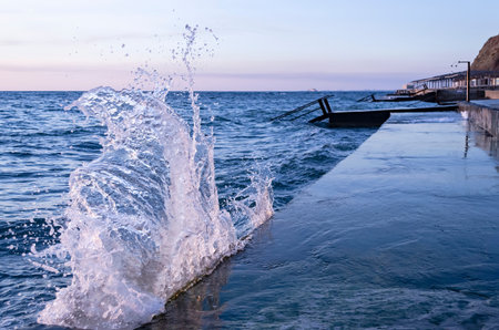 Bright sunset under the sea with waves splashes and stones.