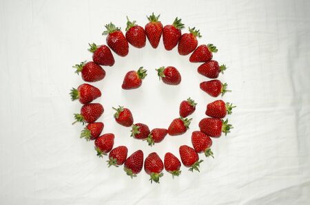 Ripe strawberry berries are laid out on a whiteの写真素材