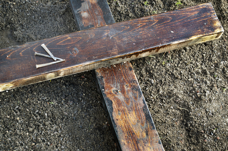 Wooden Cross on the Ground, Three Nails Along Sideの写真素材