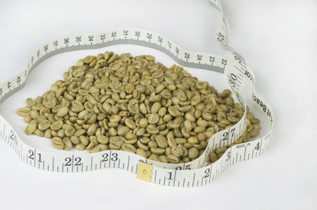 Green Raw Coffee Beans in Pile Surrounded By Cloth Tape Measureの写真素材